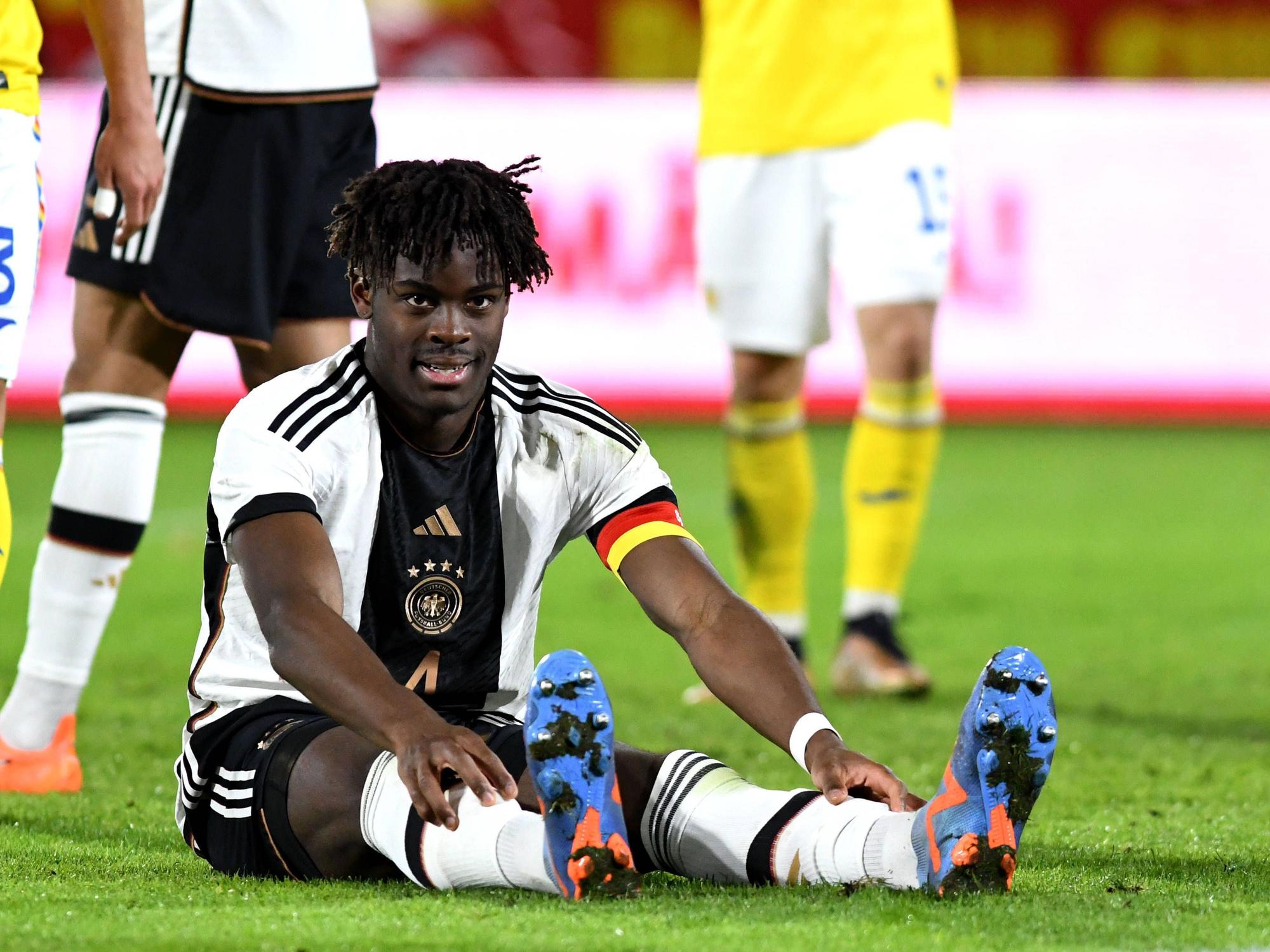 Yann Bisseck sitzt enttäuscht auf dem Boden.