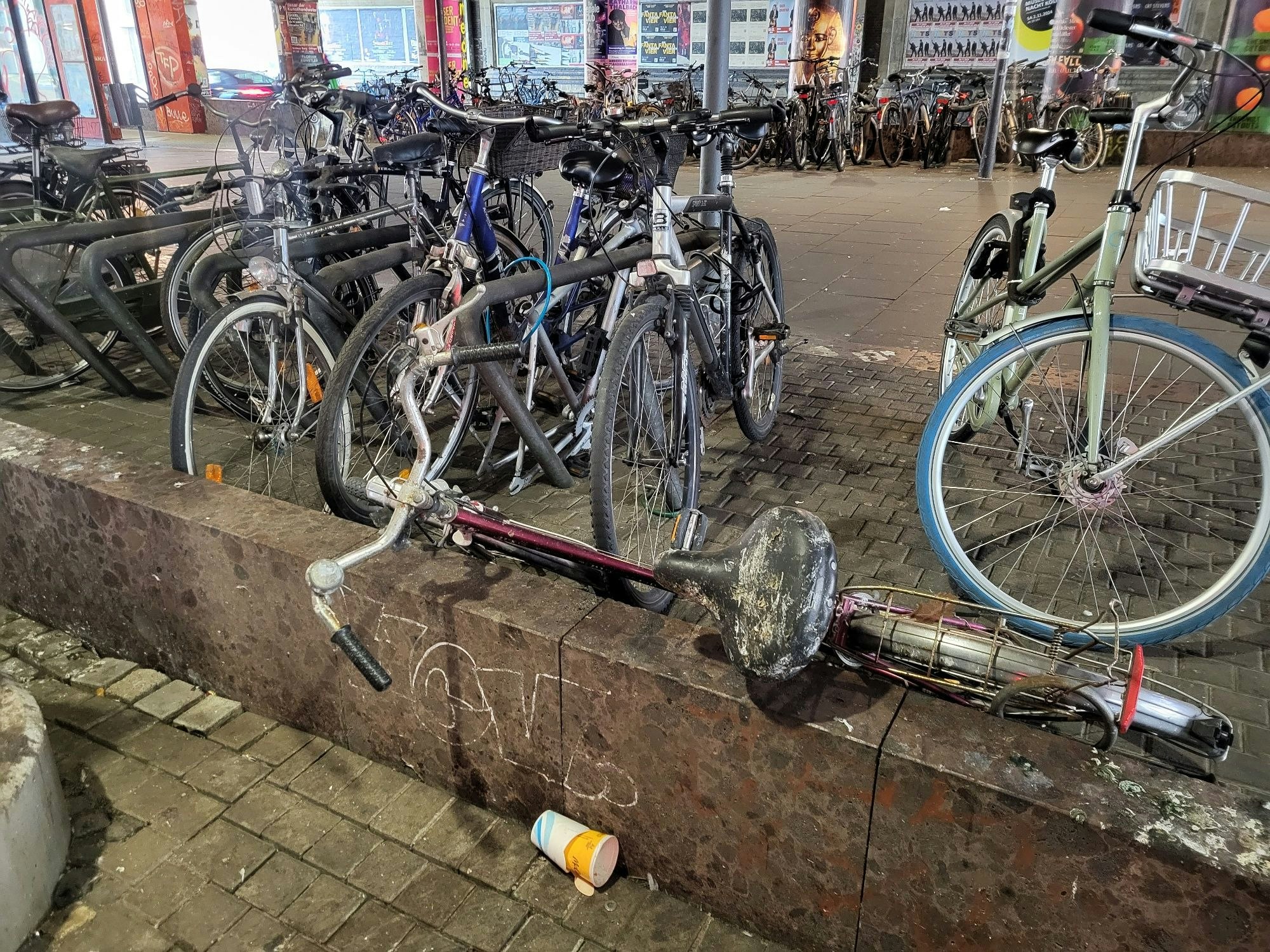 Müll und ein verdrecktes Fahrrad an der Haltestelle Hansaring in Köln.