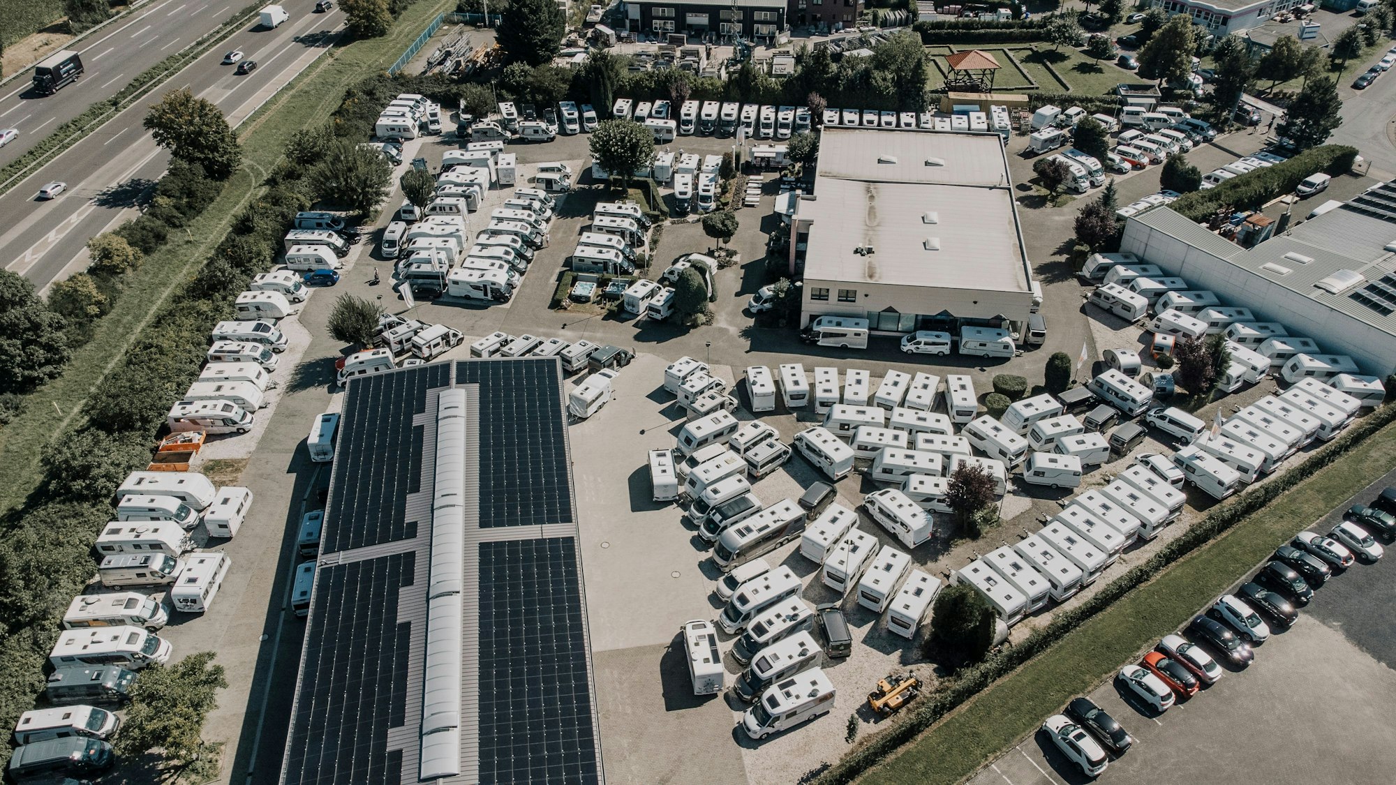 Luftaufnahme von einem Gelände, auf dem unzählige Wohnmobile stehen.