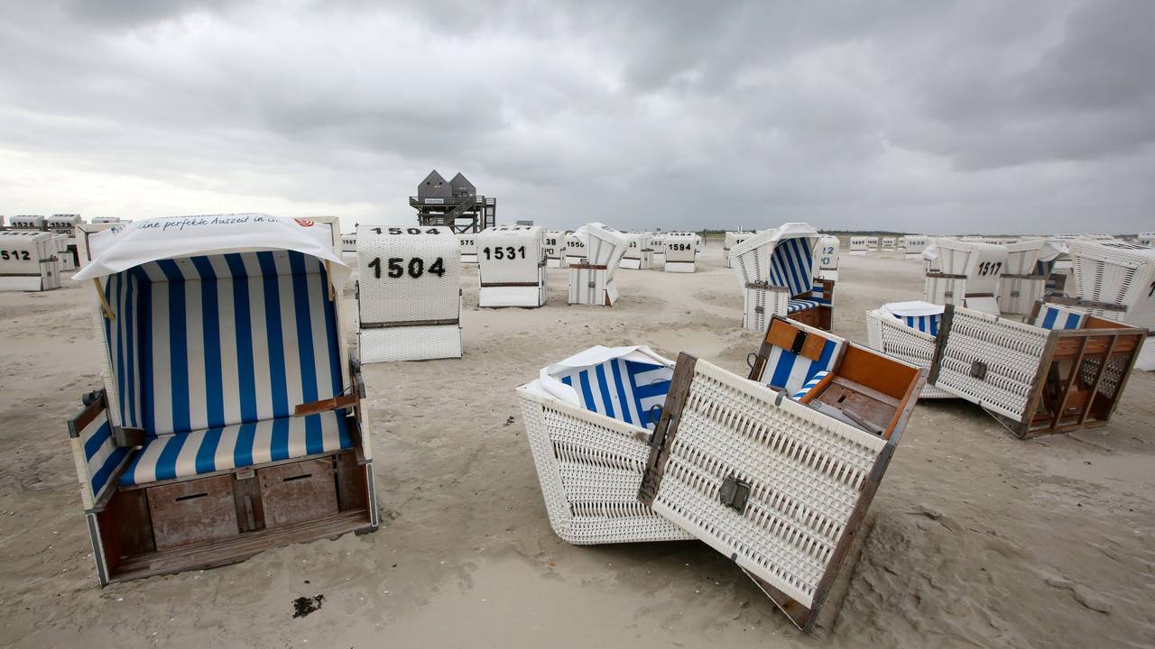 Umgekippte Strandkörbe liegen bei stürmischen Wetter am Strand von Sankt Peter Ording.