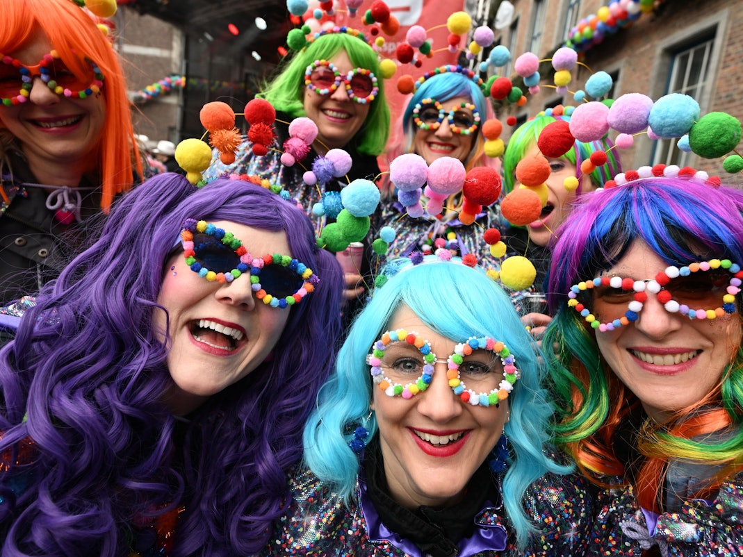 Verkleidete Jecken stehen vor dem Rathaus.