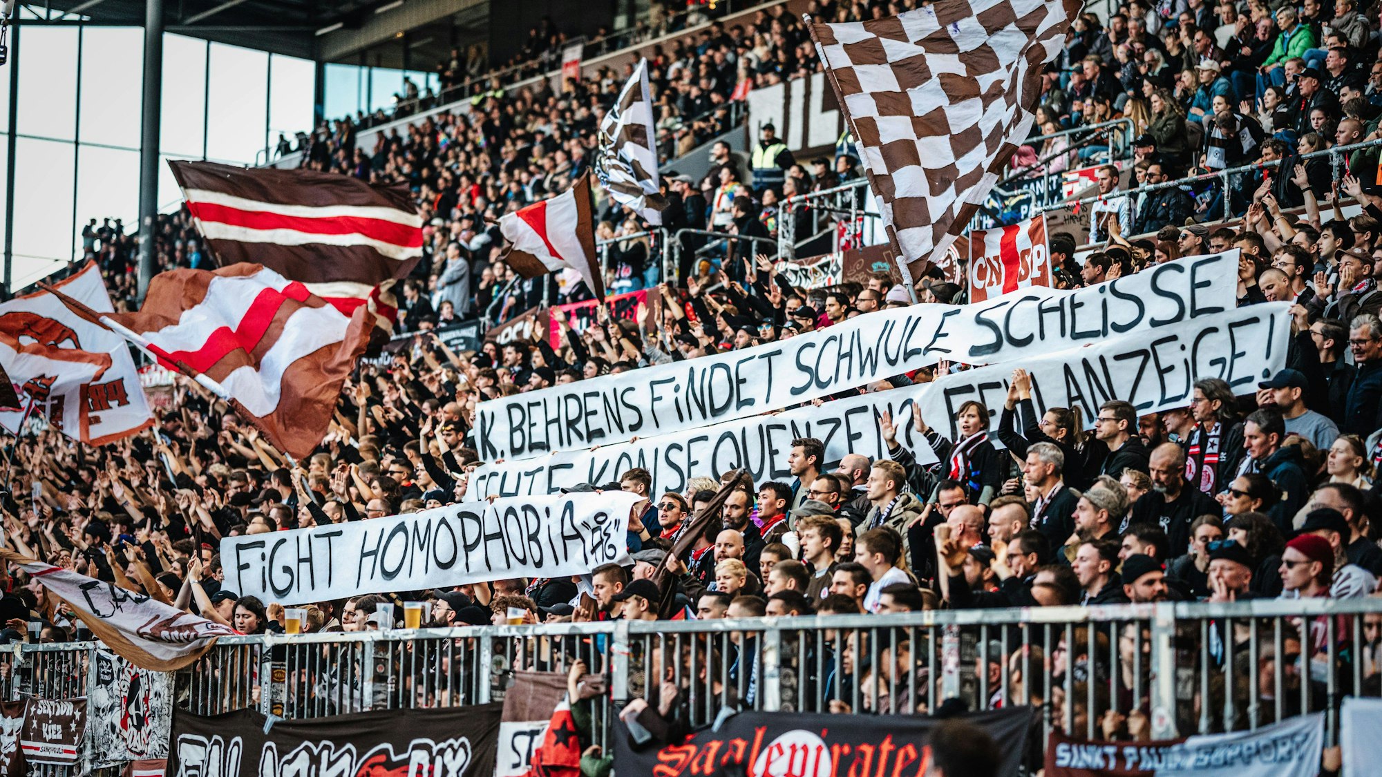Auf einem Plakat von St.-Pauli-Fans ist zu lesen: „K. Behrens findet Schwule scheiße. Echte Konsequenzen? Fehlanzeige! Fight Homophobia.“