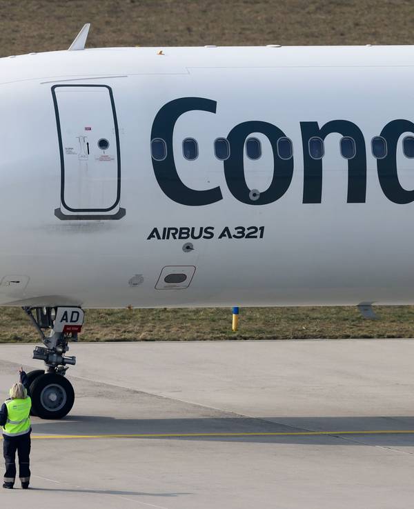 Der Pilot einer Condor-Maschine mit Ziel Teneriffa winkt dem Bodenpersonal vor dem Start vom Flughafen Leipzig/Halle.