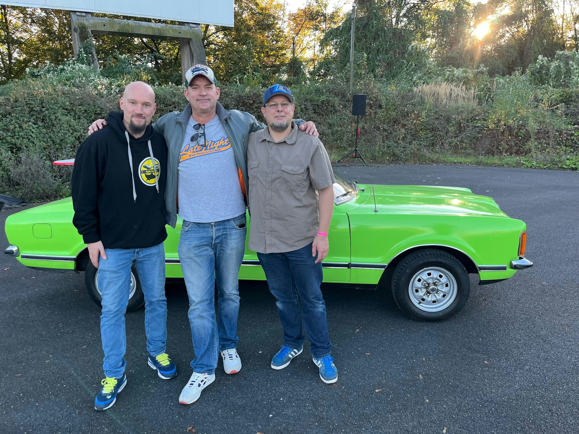 Marianus Machtemes, Schauspieler Christian Kahrmann und Christian Sorkalla posieren vor einem Ford Capri.
