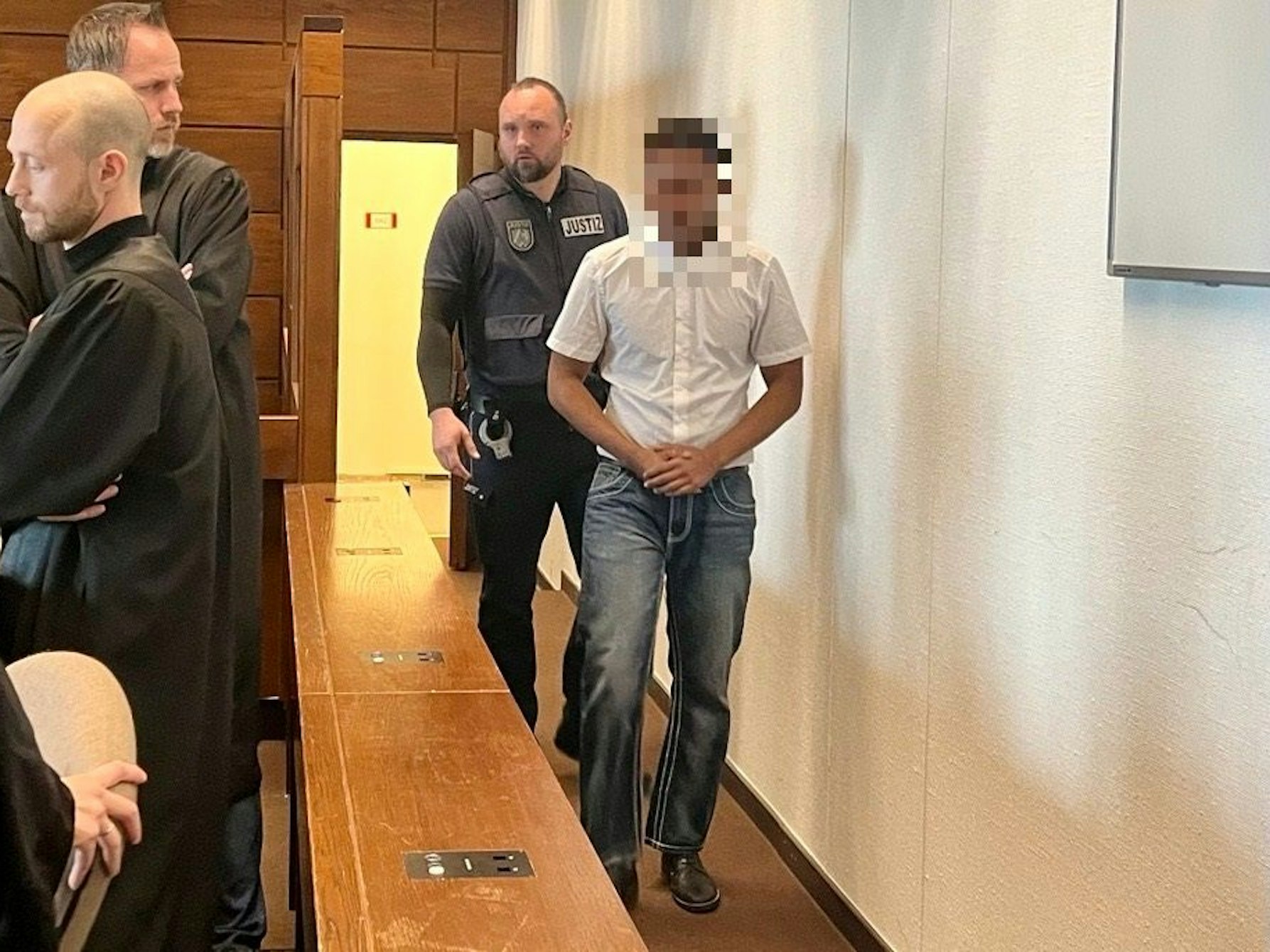 Der 19-jährige Angeklagter (19) im Mordprozess um den 15-jährigen Dara in Köln wird am Dienstag (29. Oktober 2024) in den Gerichtssaal gebracht.