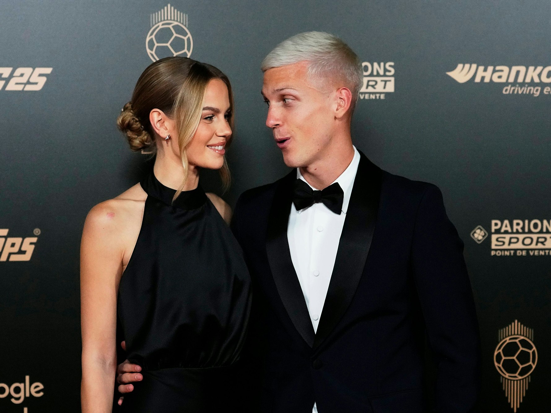Dani Olmo und Laura Abla lächeln sich auf dem Roten Teppich an.
