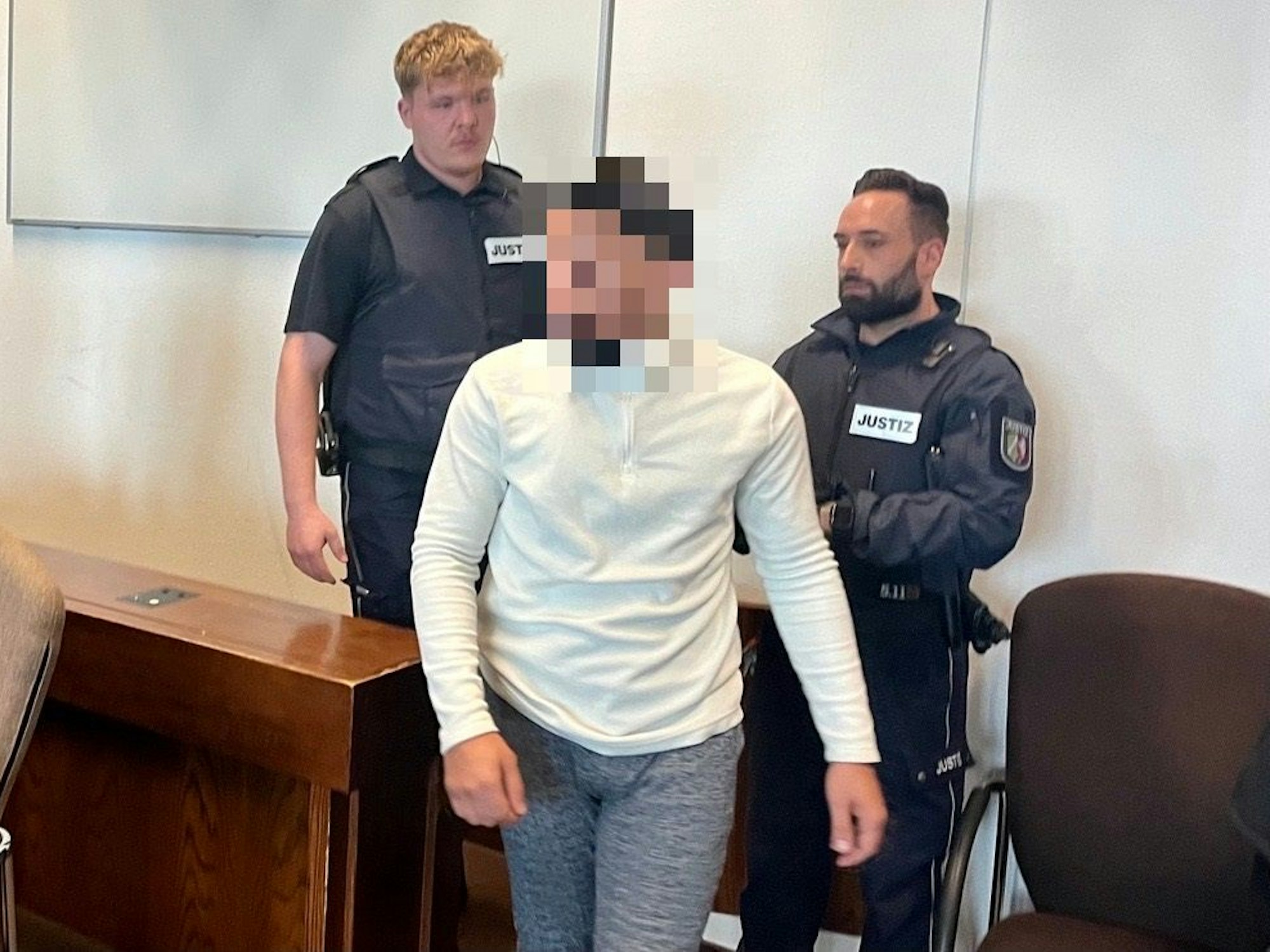 Einer der Angeklagten im Prozess um den 15-jährigen Dara in Köln betritt den Saal.
