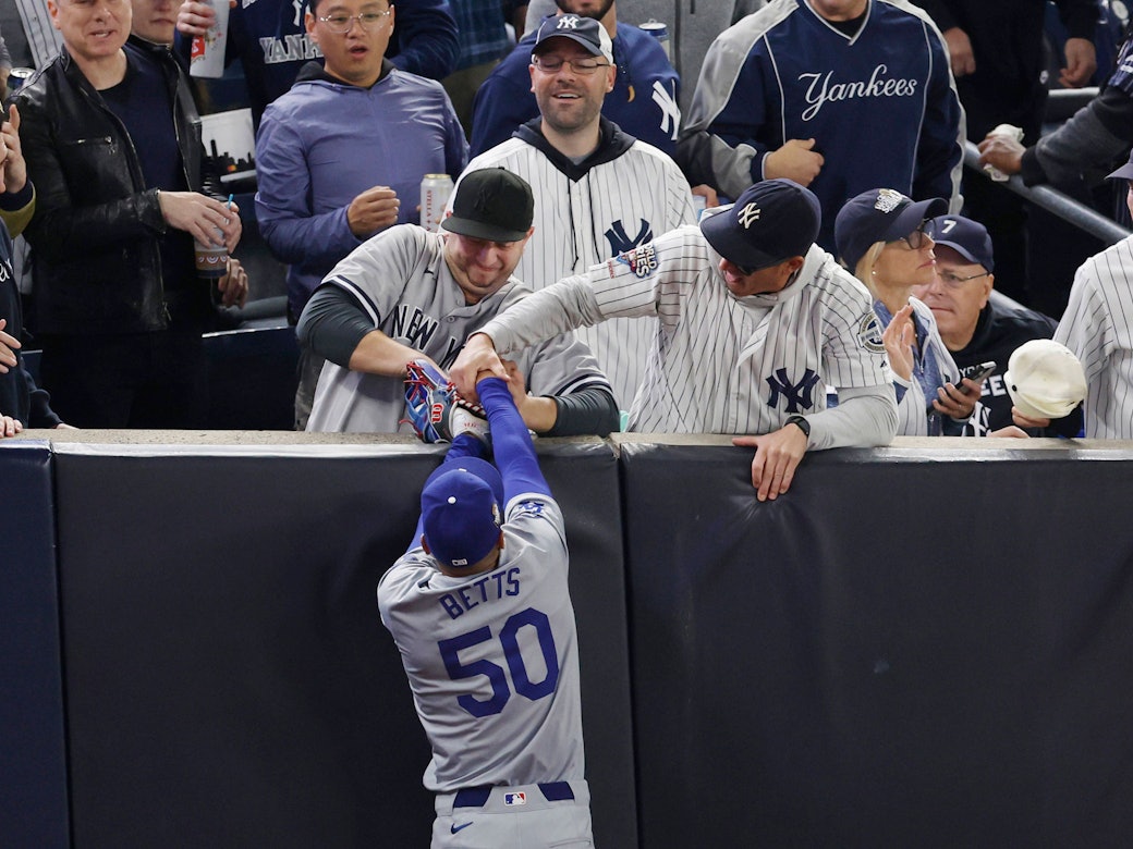Zwei Yankees-Fans reißen Dodgers-Profi Mookie Betts den Ball aus den Händen.