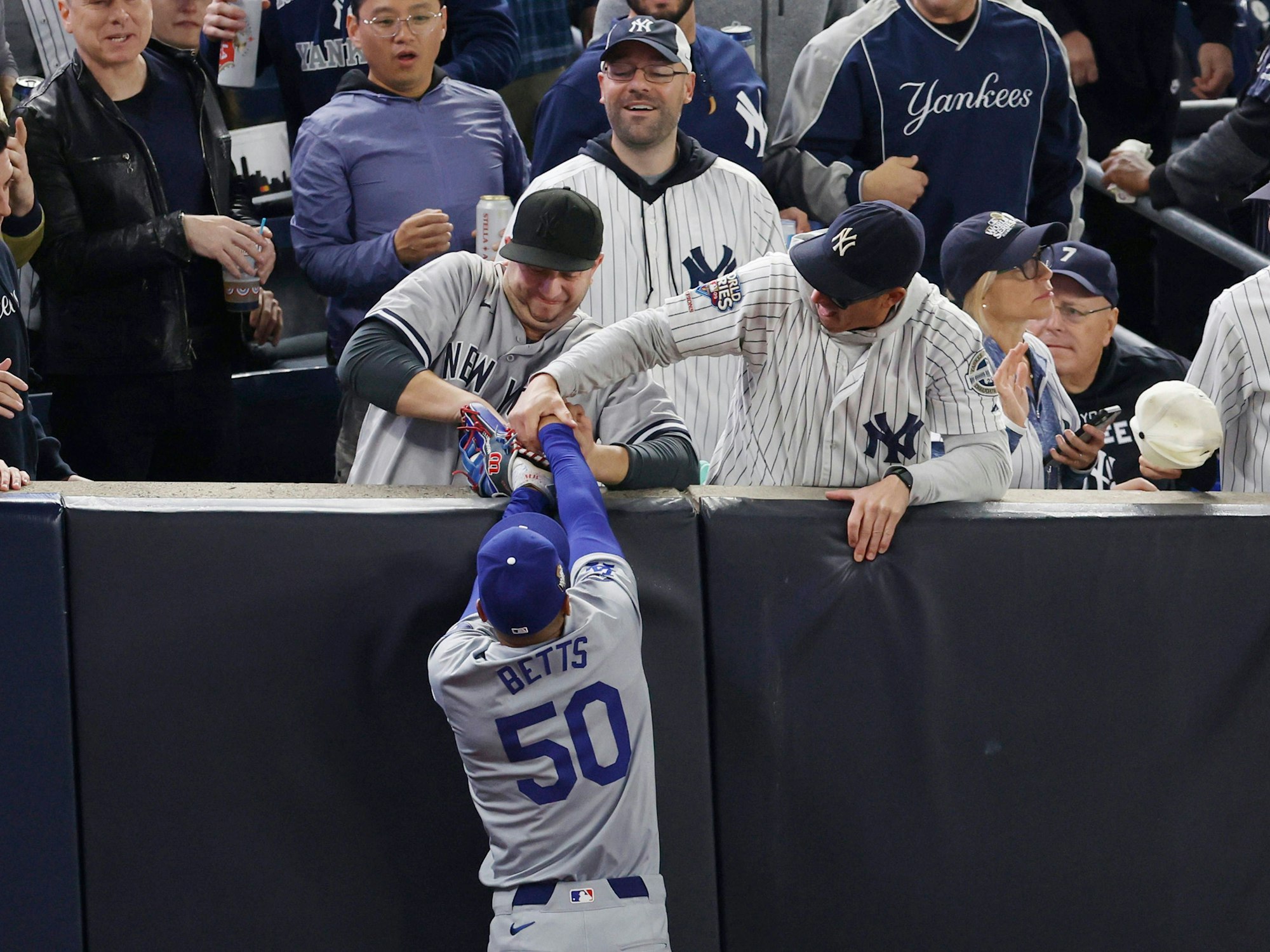 Zwei Yankees-Fans reißen Dodgers-Profi Mookie Betts den Ball aus den Händen.