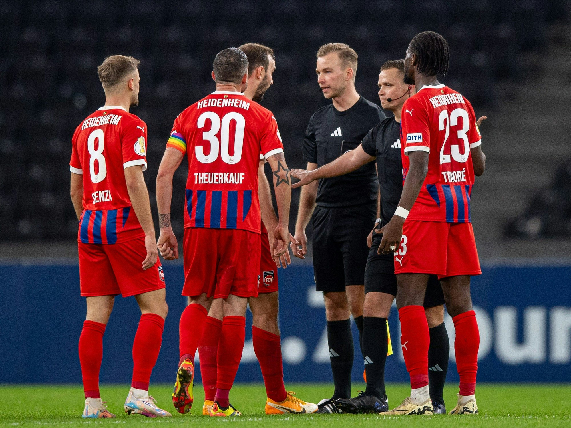 Die Heidenheim-Profis stellen Schiedsrichter Robert Kampka und Assistent Martin Wilke zur Rede. (Foto: 30. Oktober 2024)