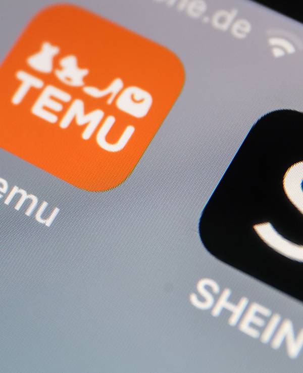 Die Apps der Internethändler Temu und Shein sind auf dem Display eines Smartphones zu sehen.