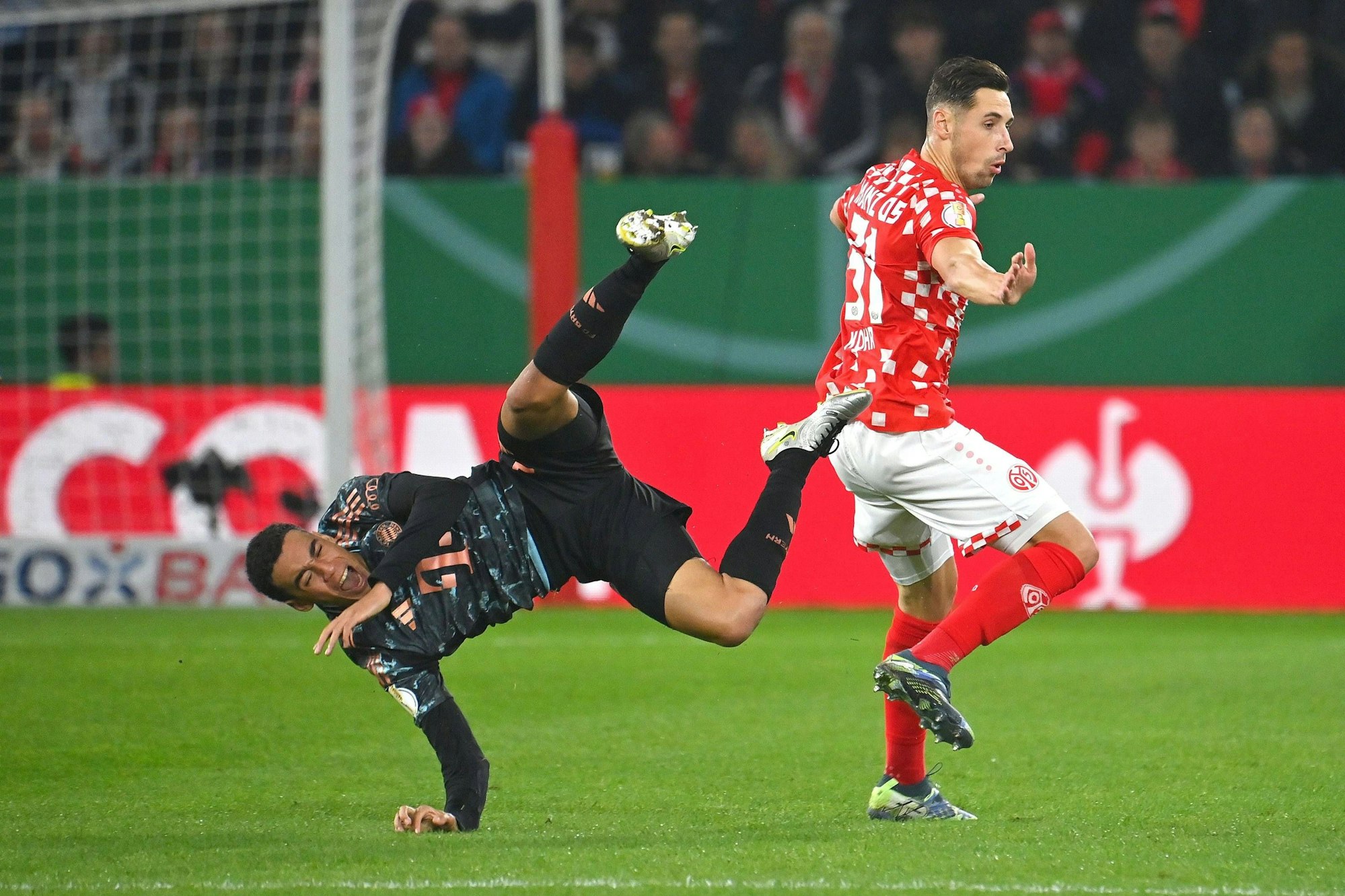 Jamal Musiala fällt nach einem Foul von Dominik Kohr.
