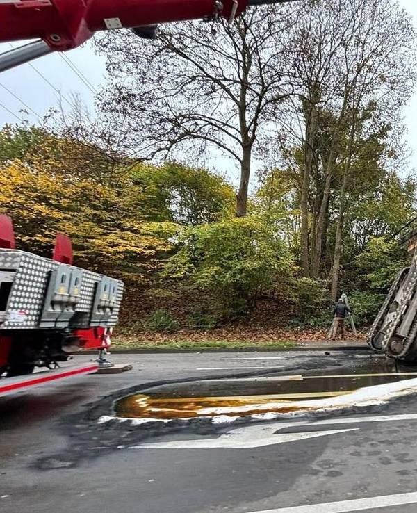 Ein Bagger liegt unter einer Brücke auf einer Fahrbahn.