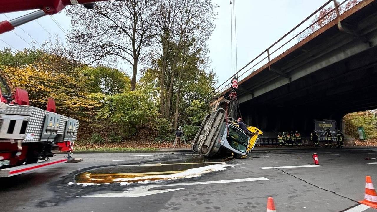 Ein Bagger liegt unter einer Brücke auf einer Fahrbahn.