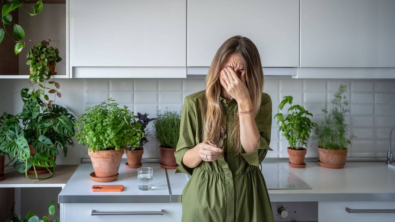 Überforderte und erschöpfte Frau in der Küche