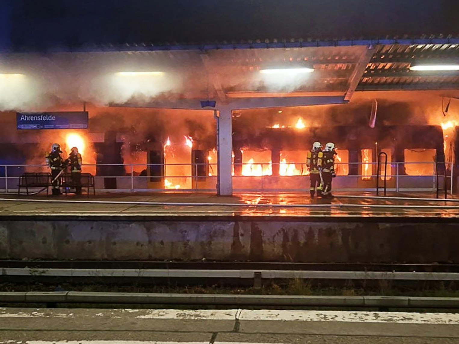 Einsatzkräfte der Feuerwehr löschen den Brand eines Zuges im S-Bahnhof Ahrensfelde.