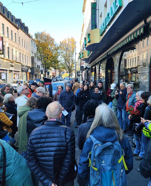 Viele Menschen auf der Kölner Keupstraße stehen zusammen.