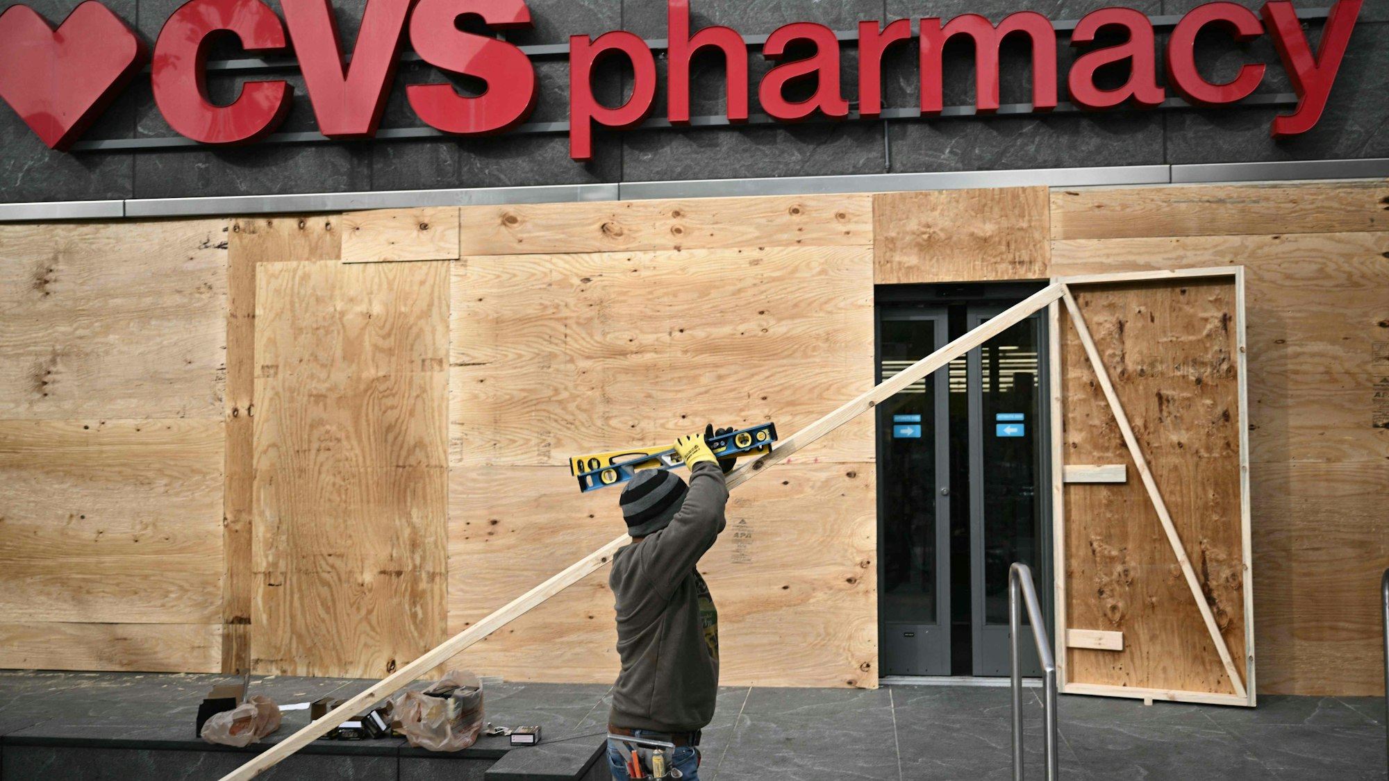 Viele Unternehmer wollen ihre Geschäfte schützen, hier vernagelt ein Mann in Washington eine Apotheke.