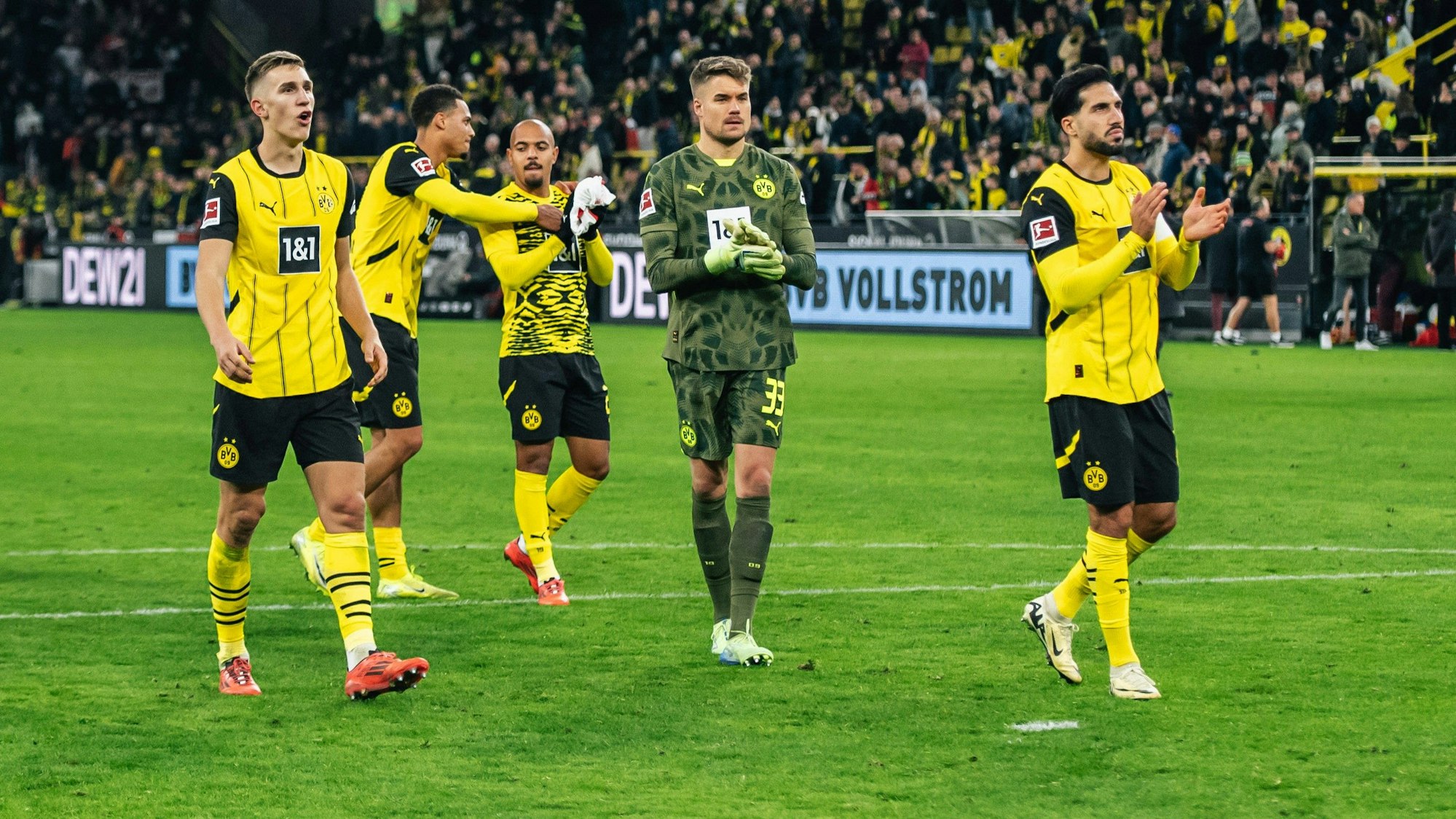 Die BVB-Profis Nico Schlotterbeck, Felix Nmecha, Donyell Malen, Alexander Meyer und Emre Can jubeln nach dem hart erkämpften 2:1-Sieg gegen RB Leipzig mit ihren Fans.