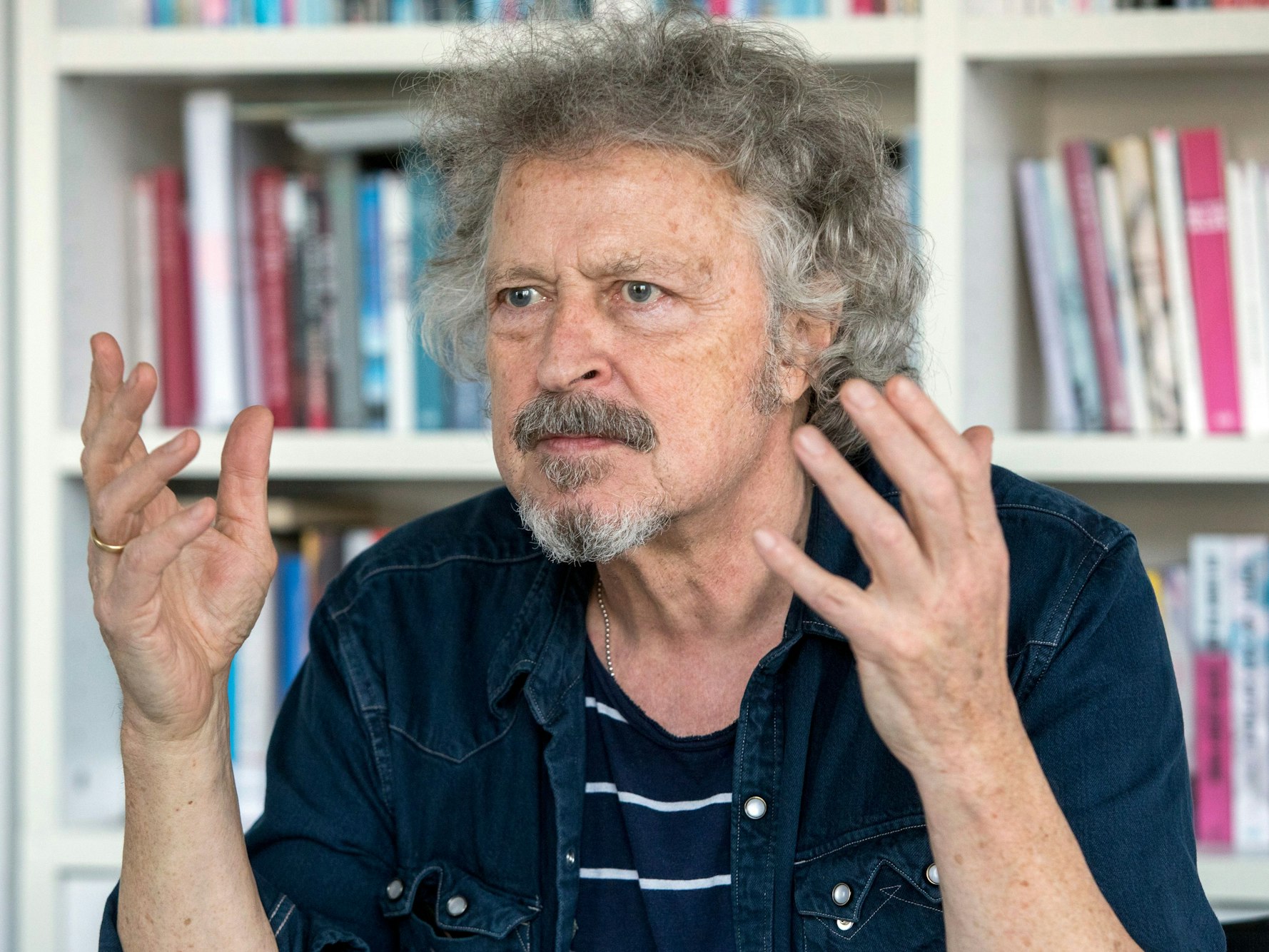 Wolfgang Niedecken gestikuliert mit den Händen während eines Interviews.