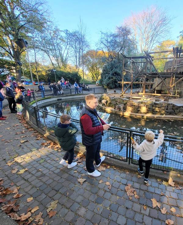 Menschen stehen am Affenfelsen im Kölner Zoo und beobachten die Tiere.