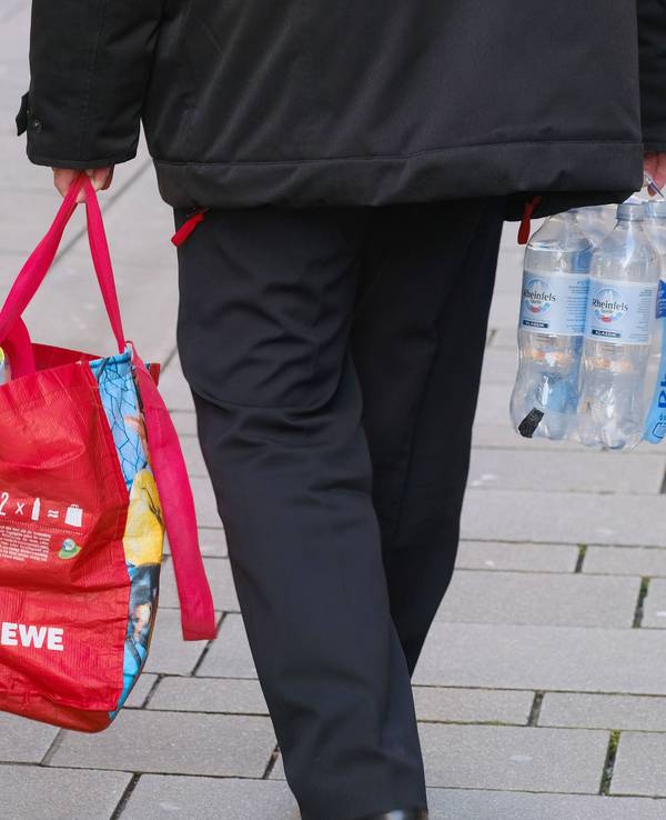 Ein Mann trägt eine Einkaufstasche.