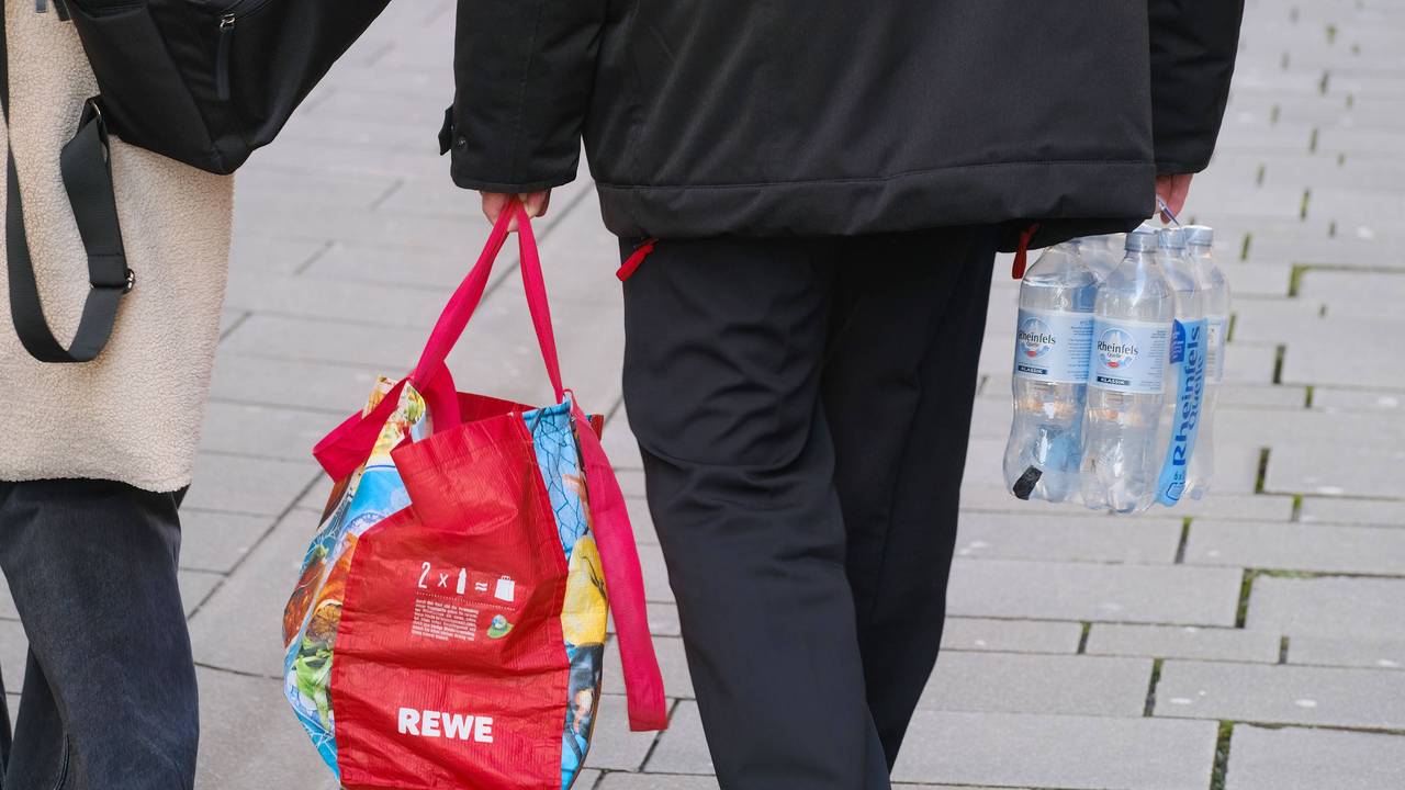 Ein Mann trägt eine Einkaufstasche.