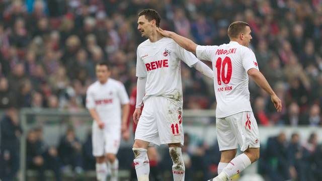Lukas Podolski und Milivoje Novakovic klatschen sich während des Spieles ab.