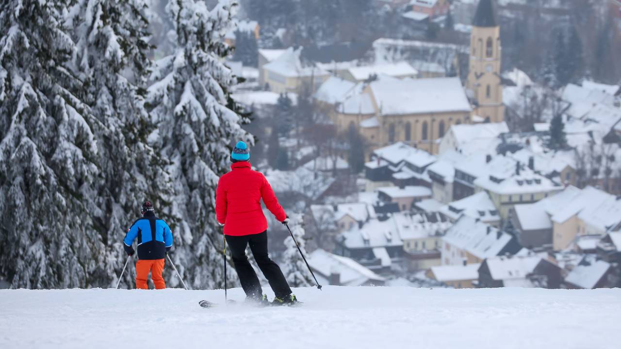 Die ersten Wintersportler fahren im Skigebiet am Fichtelberg den Hang hinab. Es ist das größte alpine Skigebiet in Sachsen.