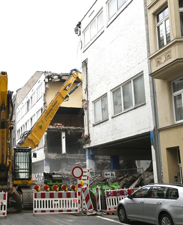 Eine gesperrte Straße mit einer großen Baustelle im Hintergrund. In der Antwerpener Straße in Köln wird die Grundschule abgerissen und neu aufgebaut.