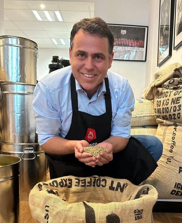 Georg Hembsch zeigt in seinem Laden einen großen Sack mit Rohkaffee.