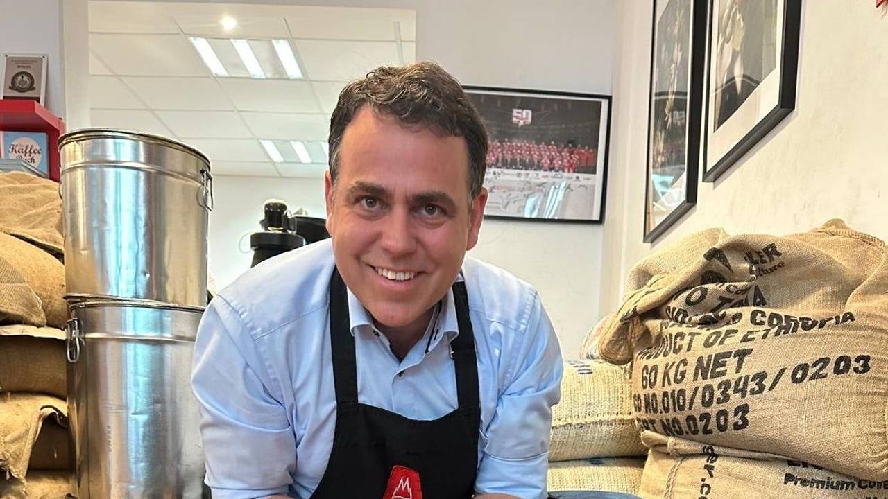 Georg Hembsch zeigt in seinem Laden einen großen Sack mit Rohkaffee.