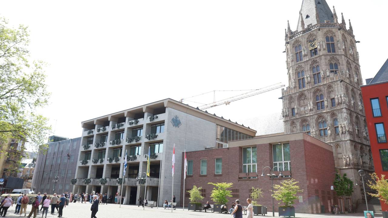 Das Historische Rathaus am Alter Markt in Köln. Davor stehen einige Passantinnen und Passanten.
