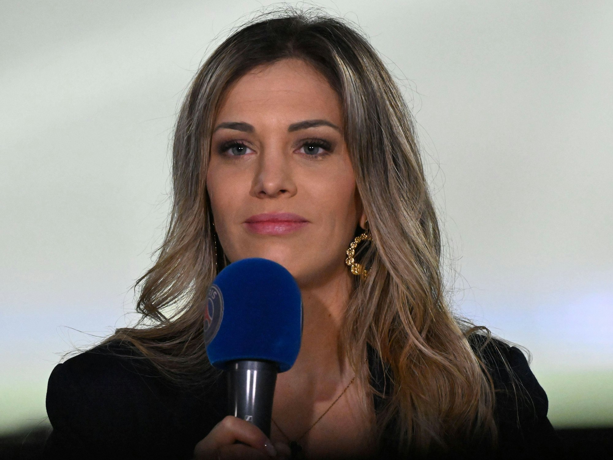 DAZN-Reporterin Ambre Godillon hält ein Mikrofon in der Hand.