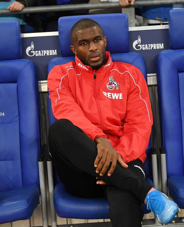 Anthony Modeste sitzt im Trainingsanzug des 1. FC Köln auf der Ersatzbank auf Schalke.