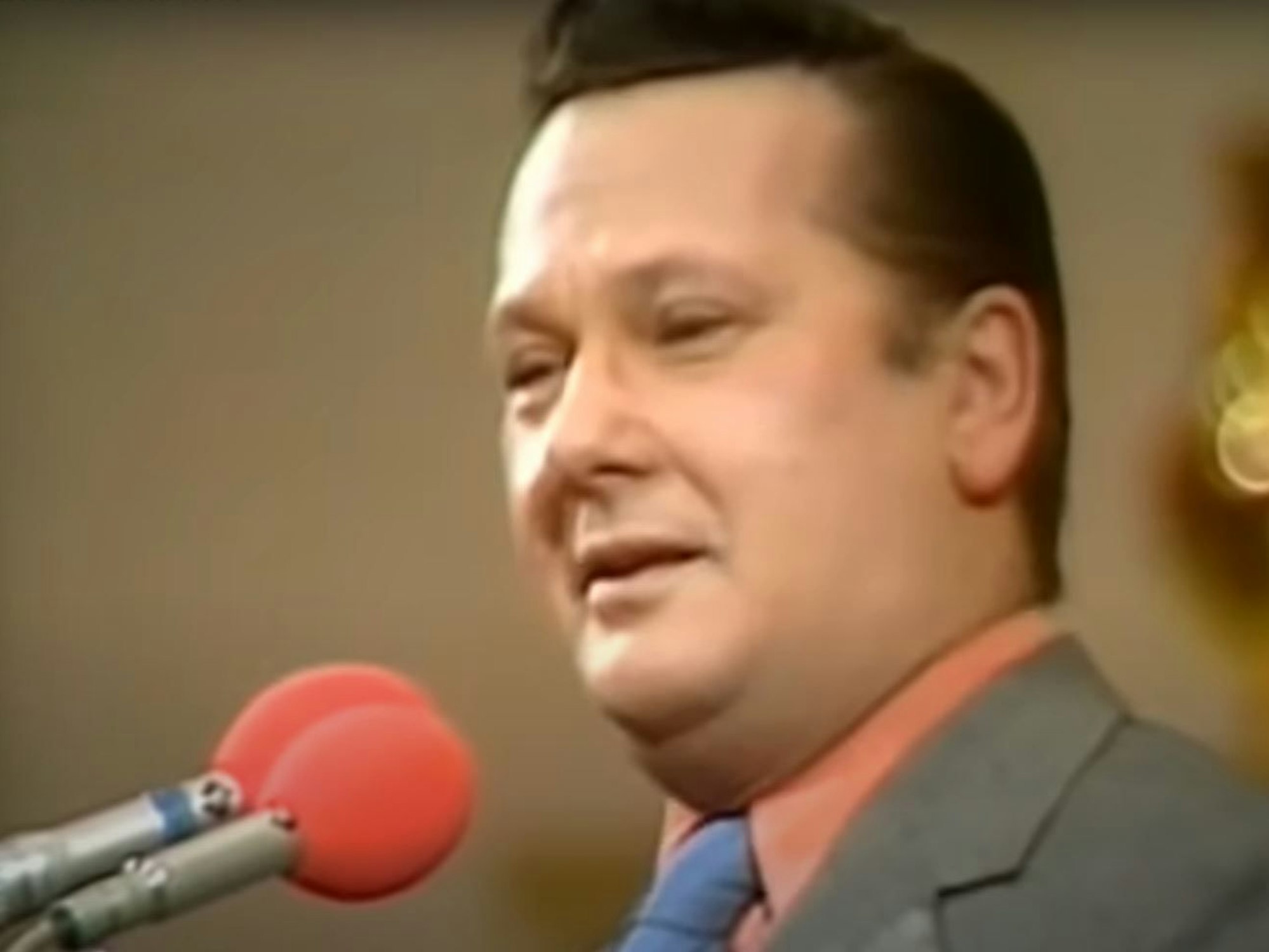 Jonny Buchardt steht grinsend am Mikrophon.