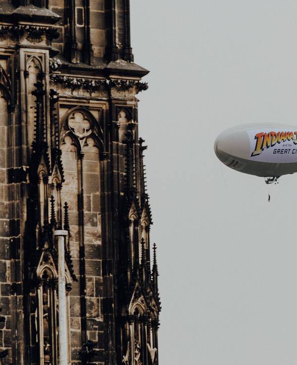 Luftschiff mit Aufdruck zu Indiana Jones am Kölner Dom zu sehen.