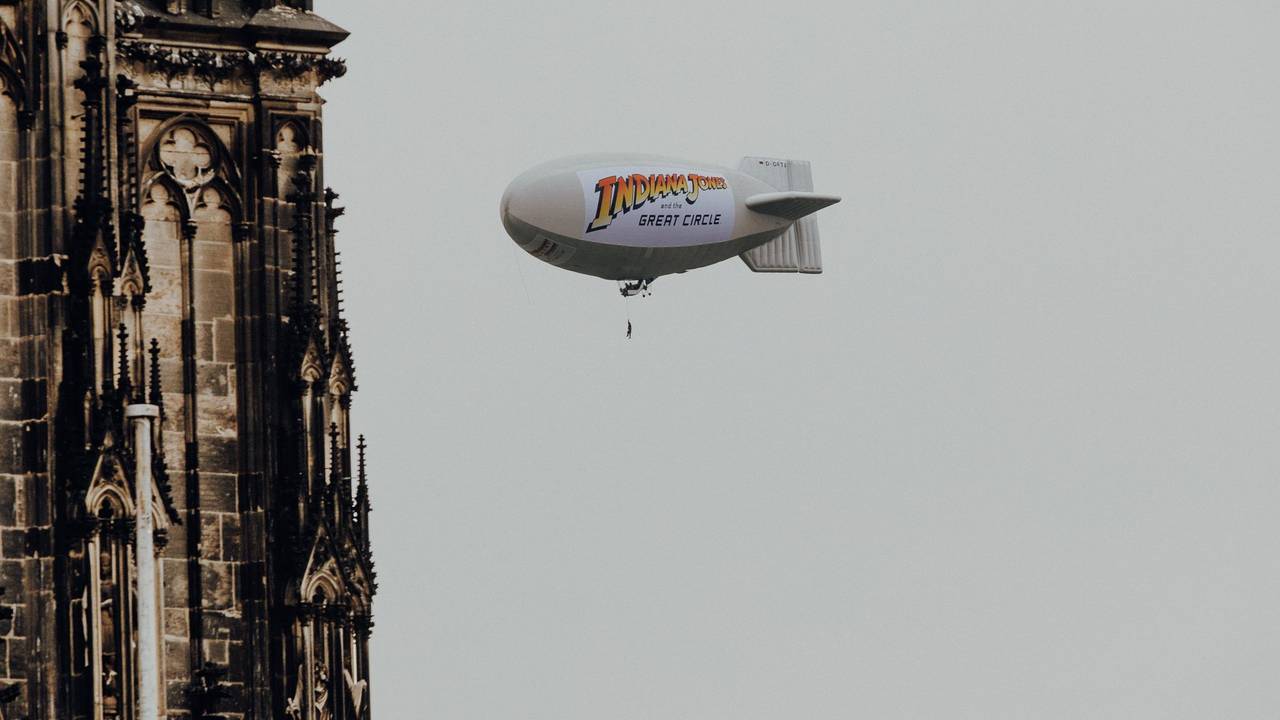 Luftschiff mit Aufdruck zu Indiana Jones am Kölner Dom zu sehen.
