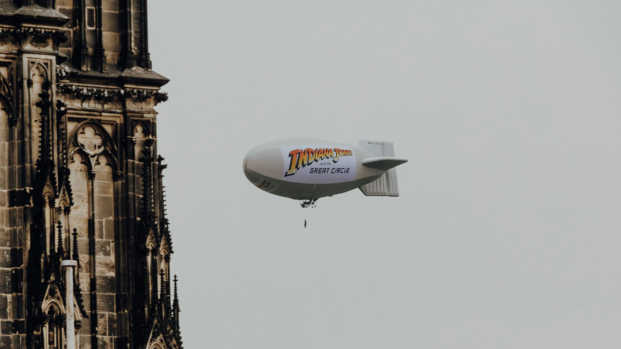 Luftschiff mit Aufdruck zu Indiana Jones am Kölner Dom zu sehen.