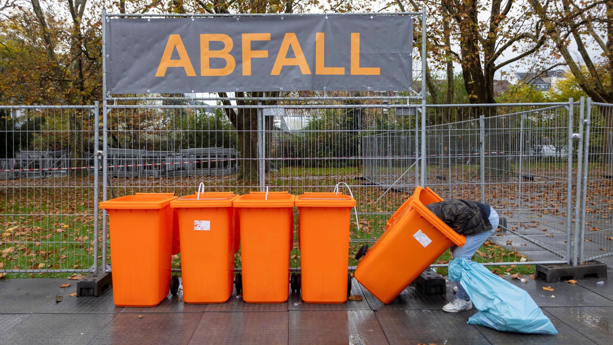 Ein Mann sucht am 11.11. in Kölner Abfalltonnen nach Pfandflaschen.