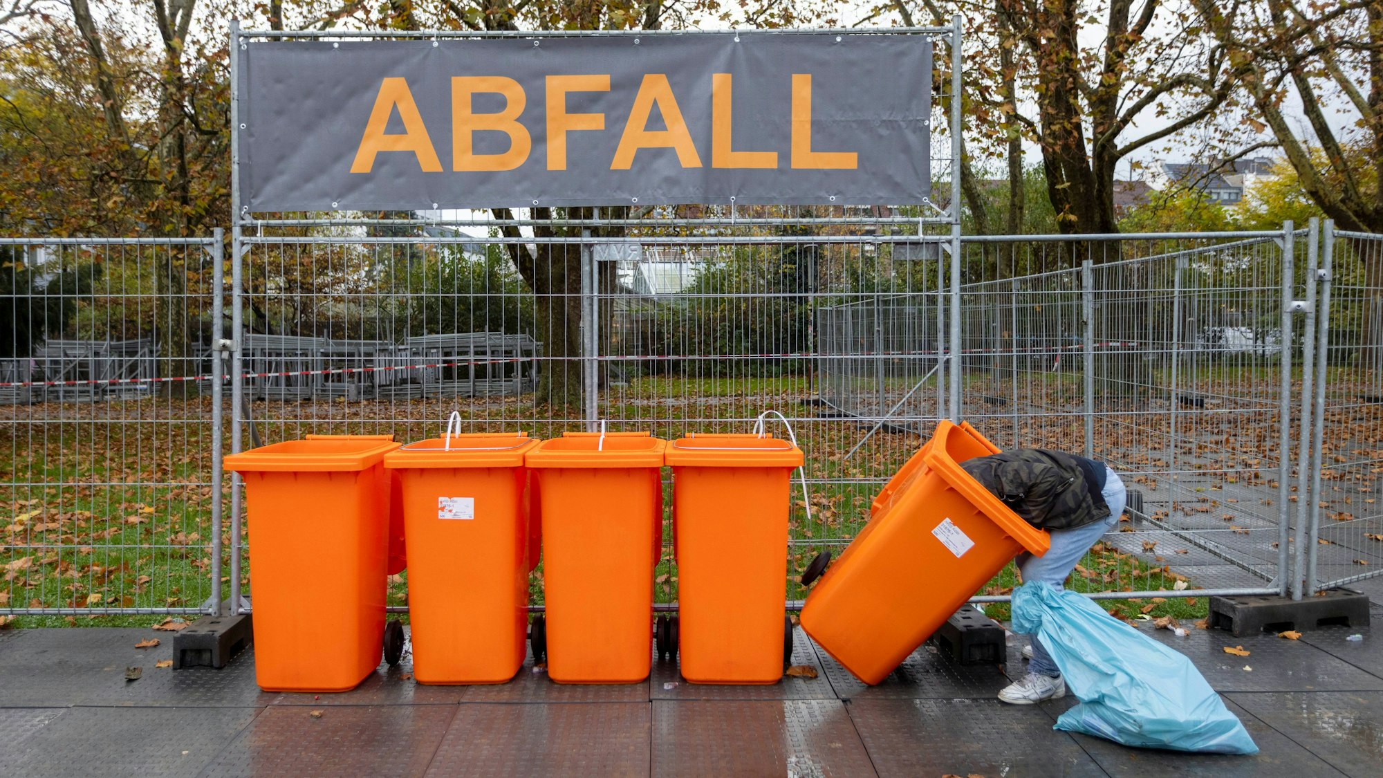 Ein Mann sucht am 11.11. in Kölner Abfalltonnen nach Pfandflaschen.