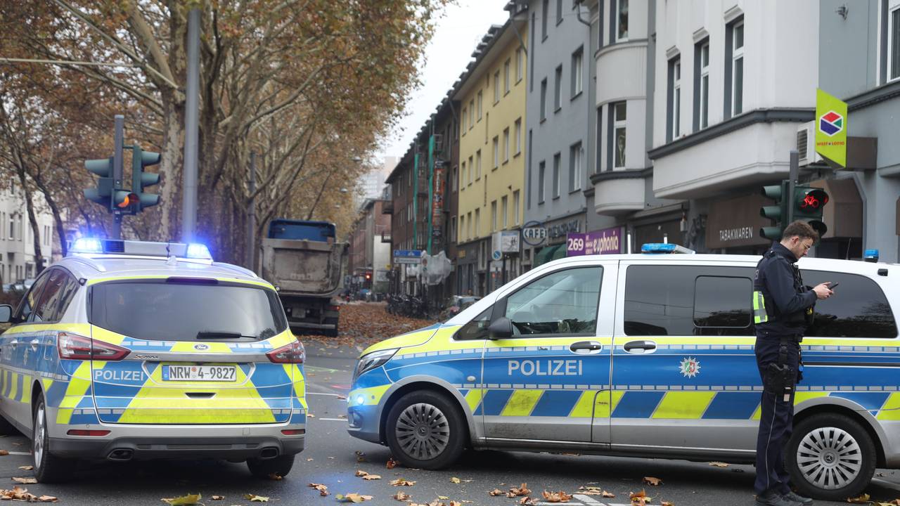 Zwei Polizeifahrzeuge stehen auf einer Straße.