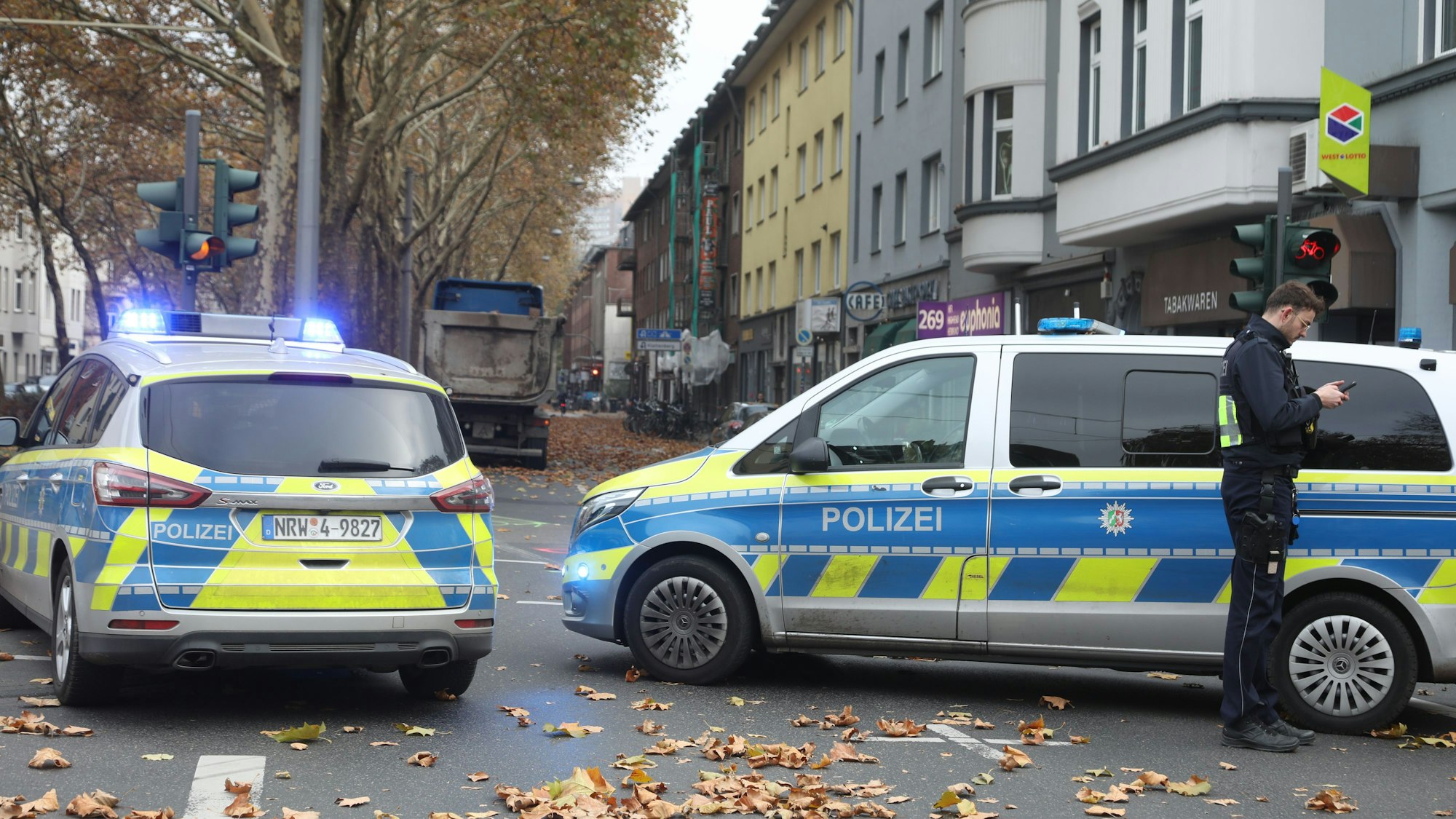 Zwei Streifenwagen stehen auf einer Straße.