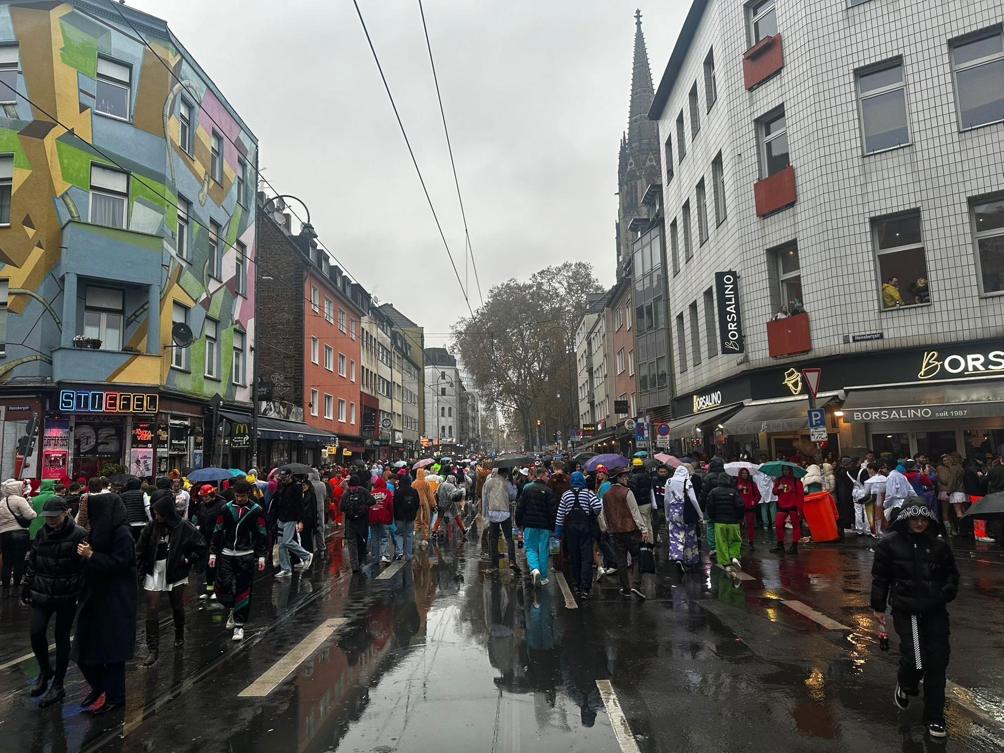 Viele Menschen und Regenschirme am 11.11. auf der Zülpicher Straße.