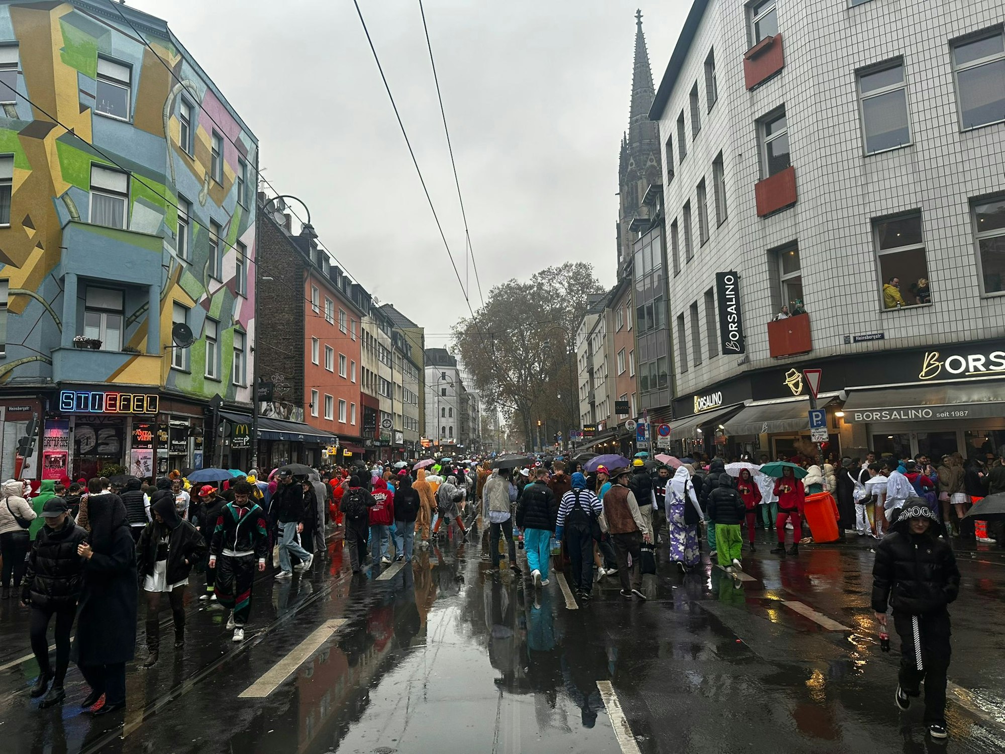 Viele Menschen und Regenschirme am 11.11. auf der Zülpicher Straße.