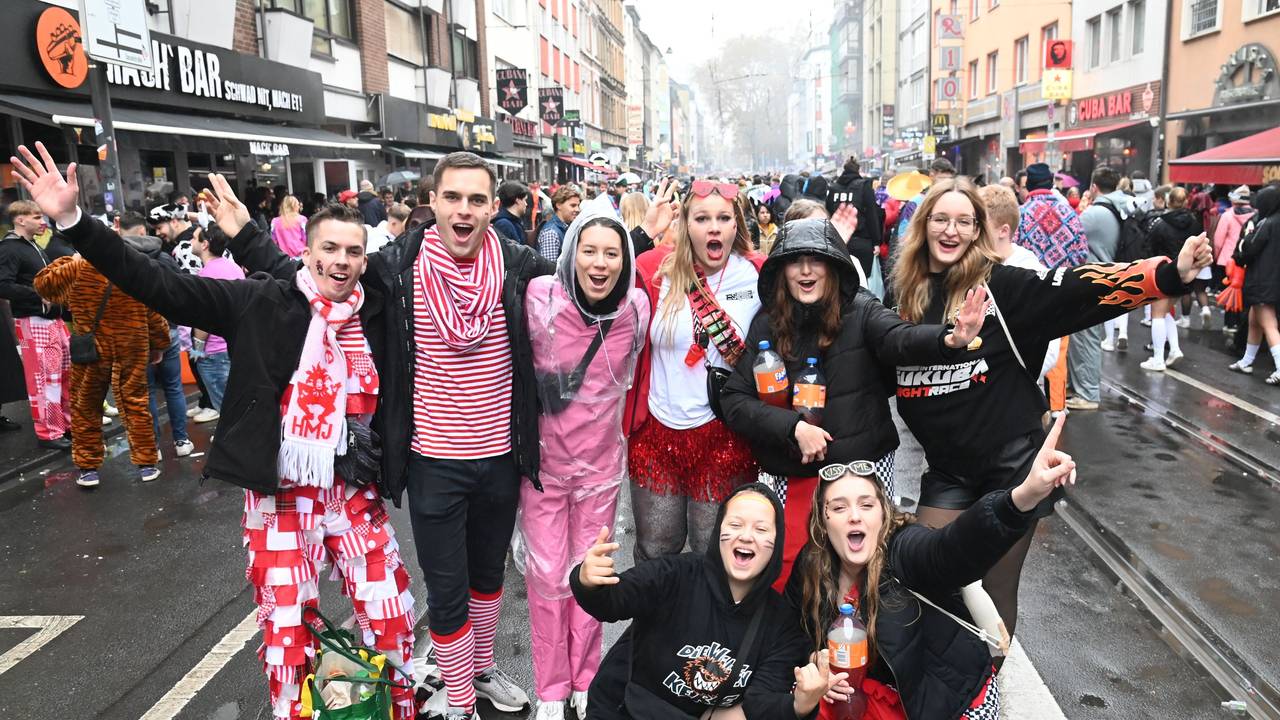Eine Gruppe junger Menschen steht zusammen und feiert.