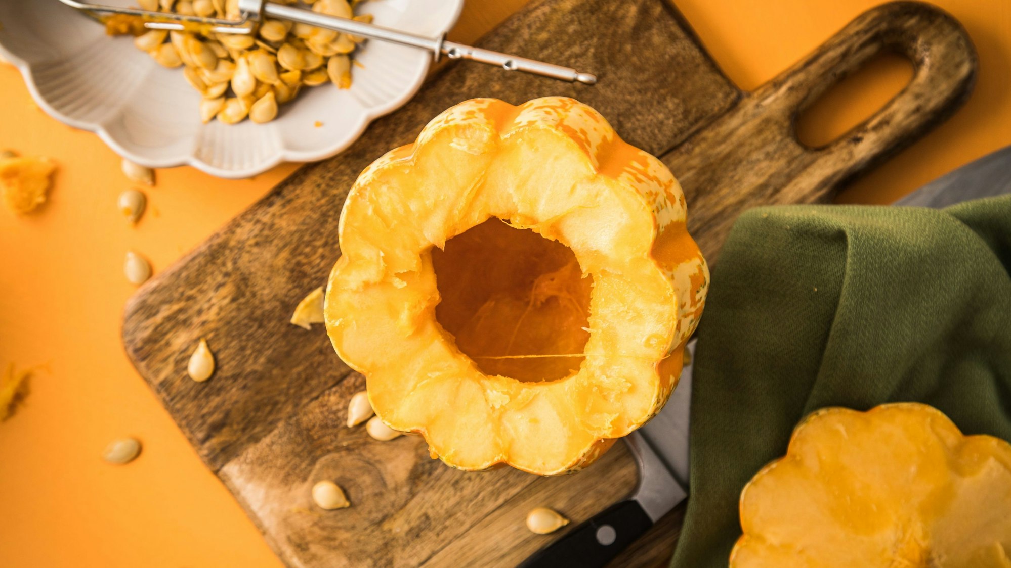 Ein ausgehöhlter Kürbis liegt auf einem Schneidebrett aus Holz.