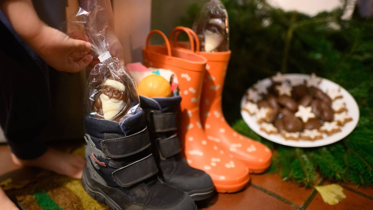 Kinderstiefel, gefüllt mit Schoko-Nikoläusen, Mandarinen und weiteren Sachen, stehen vor einer Haustür eines Einfamilienhauses in der Region Hannover.