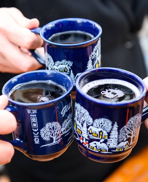 Das Foto von Dezember 2022 zeigt drei Tassen Glühwein auf dem Weihnachtsmarkt.
