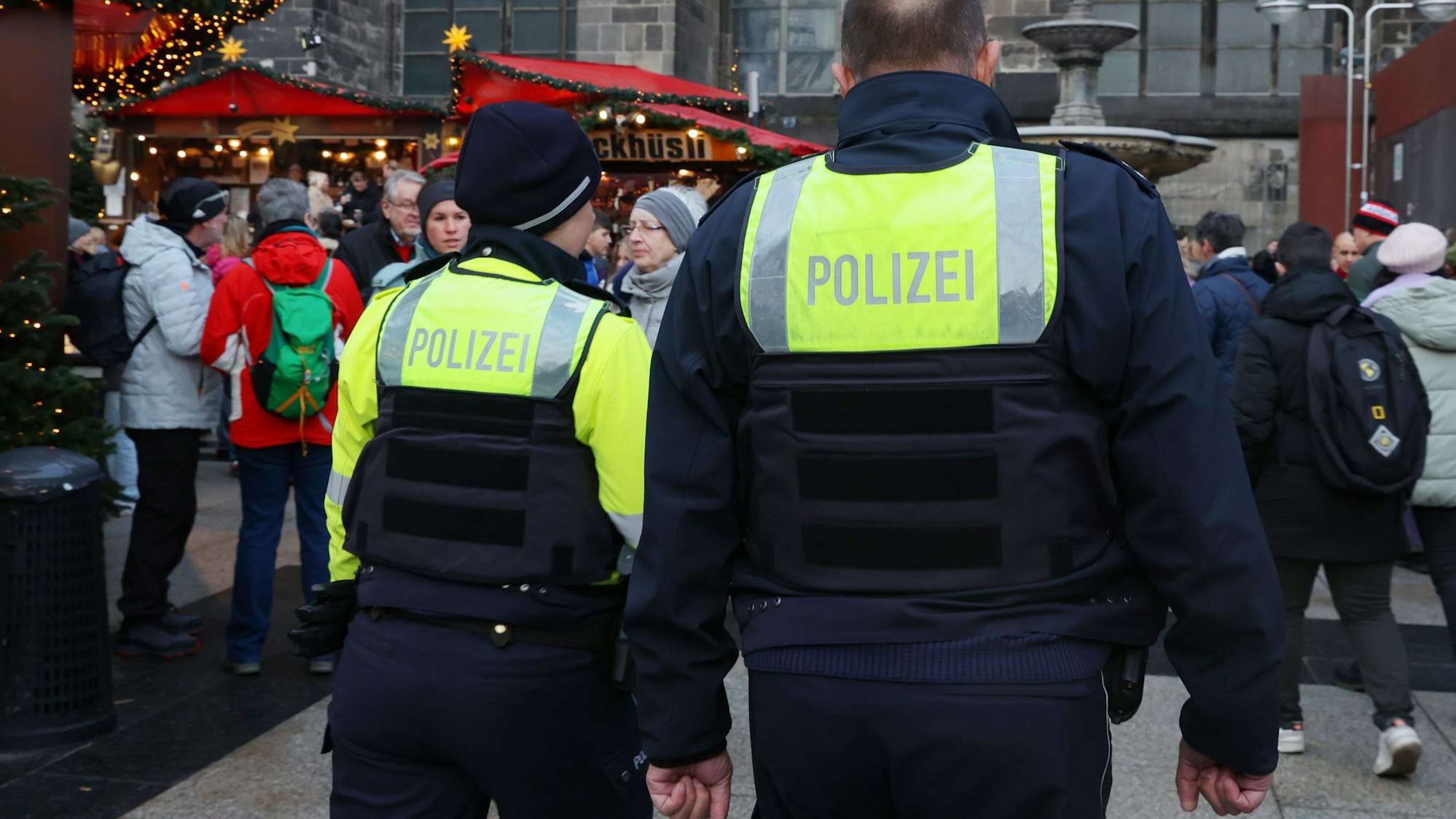 Eine Polizistin ist mit ihrem Kollegen auf einem Weihnachtsmarkt unterwegs.